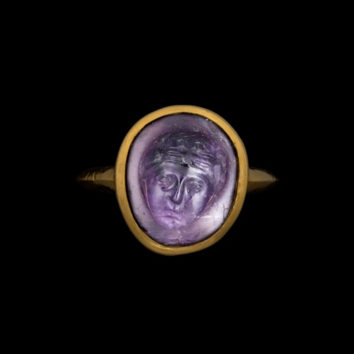 A gold ring set with a rare Roman amethyst cameo. Mask of Bacchus.